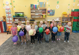 Dzieci bawią się balonami na dywanie